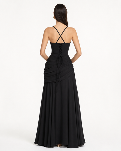 Back view of the black dress with crossed straps, lace-up corset back and draped hip. 14