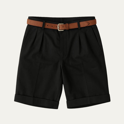 Black pleated shorts with turn-up hems, laid flat from the front with a tan leather belt and gold-toned buckle. 11