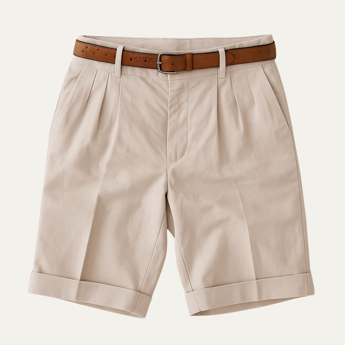 Stone pleated shorts with turn-up hems, laid flat and shown from the front with a tan leather belt threaded through. 2