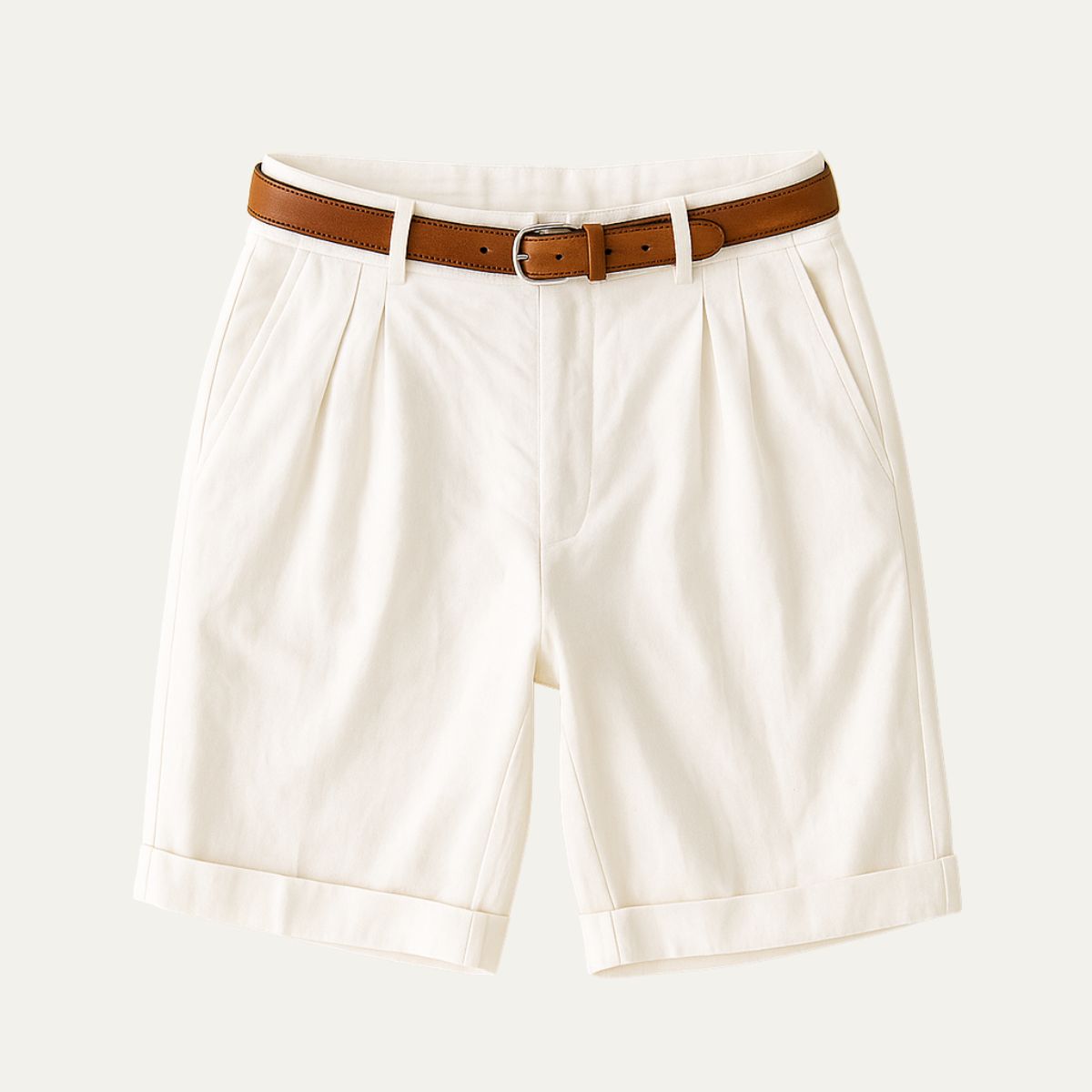 Cream pleated shorts with turn-up hems, laid flat from the front with a tan leather belt. 7