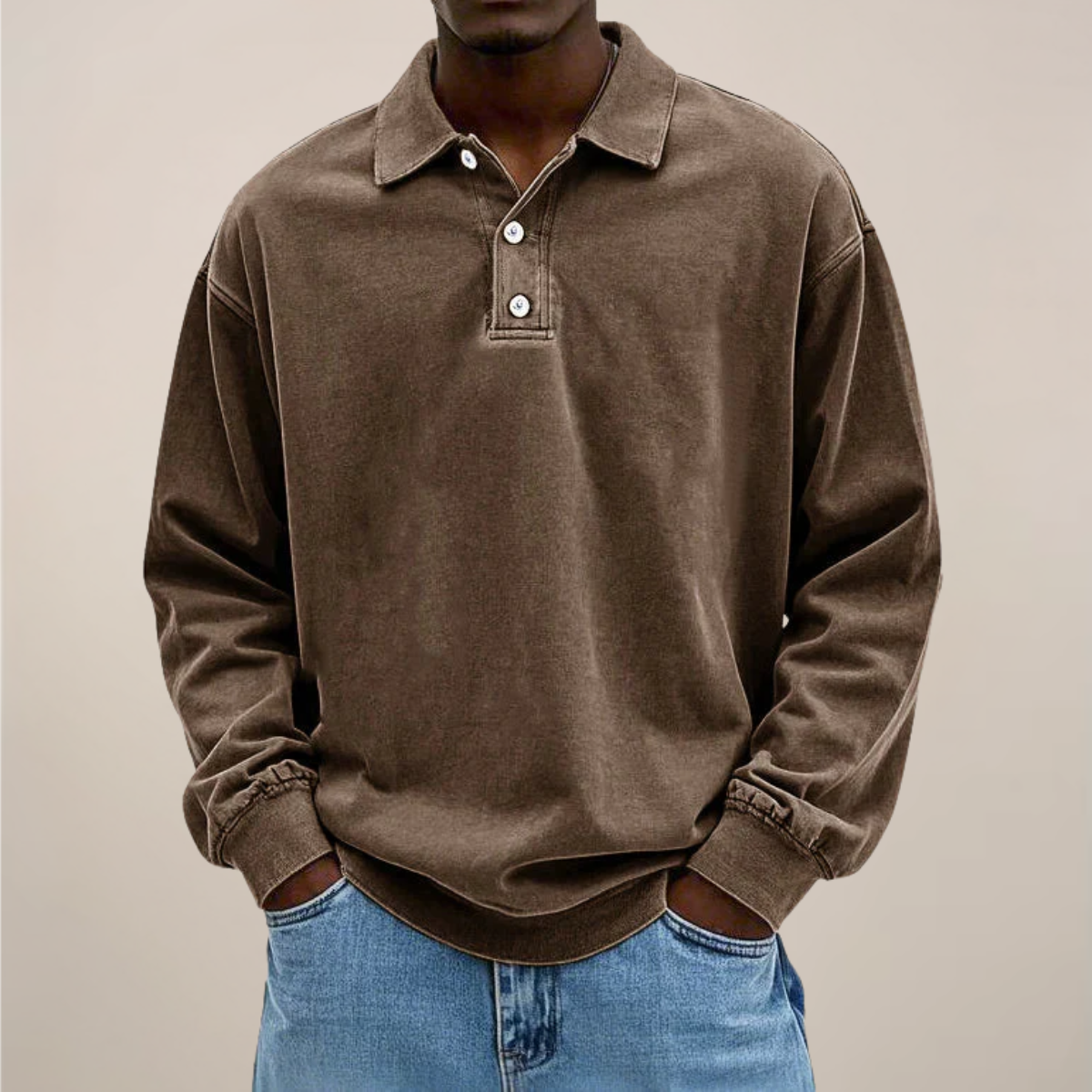 Model wearing the washed polo in chocolate brown, front view, hands in jeans pockets, ribbed cuffs and hem visible. 3