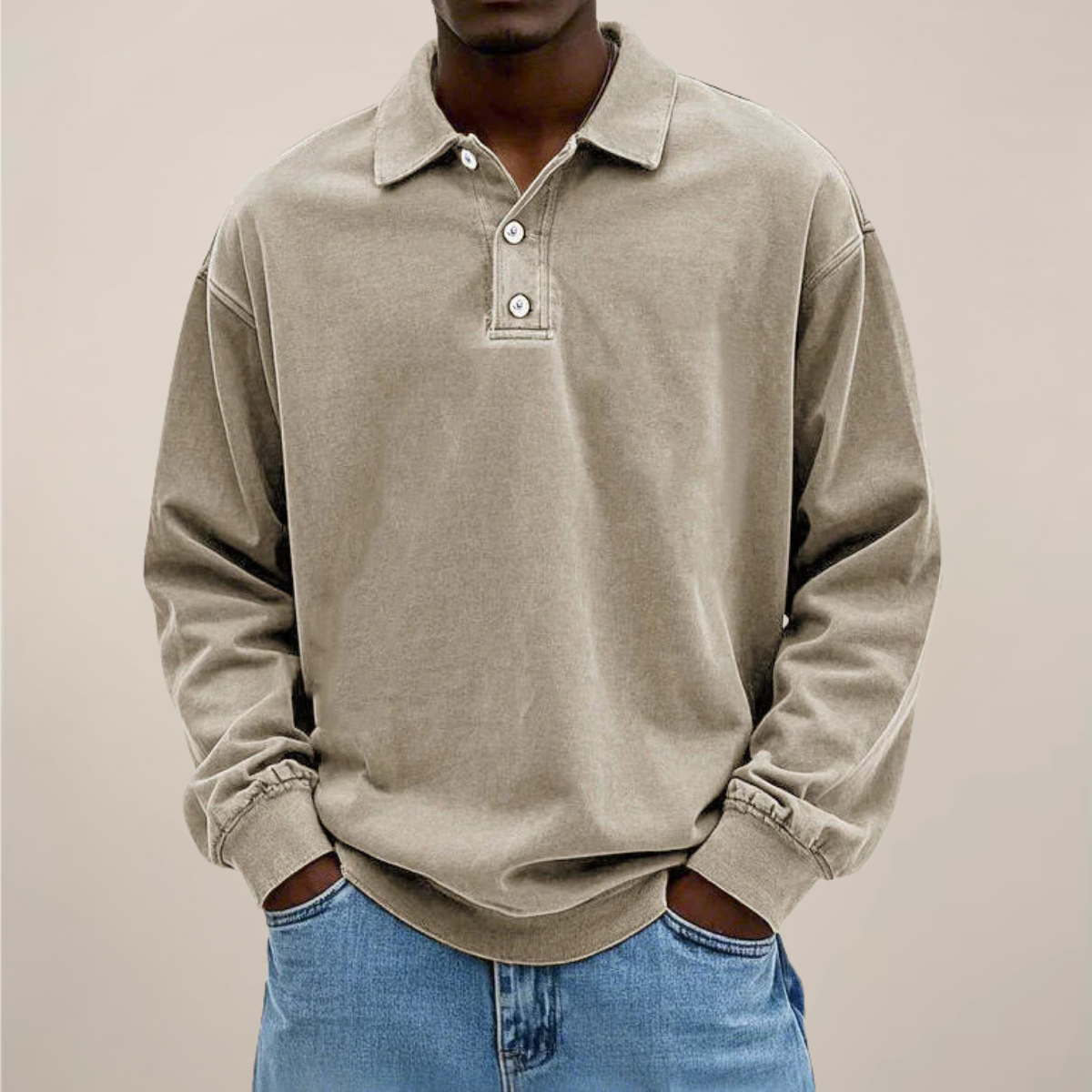 Front view of the polo in washed sandy beige, worn by a model with hands in the pockets of blue jeans. 6