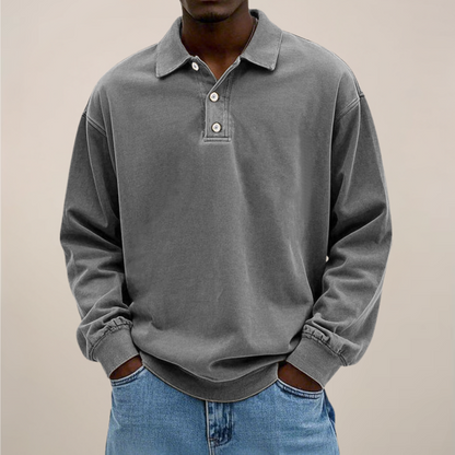 Model wearing the long sleeve polo in washed mid grey, front view with collar, button placket and ribbed cuffs. 7