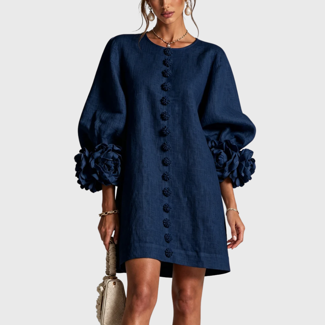 Front view of the dress in navy blue on a model, with matching flower buttons and rosette sleeve trims. 3