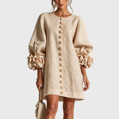 Front view of the dress in sand beige on a model, with tonal flower buttons and oversized cuff rosettes. 6