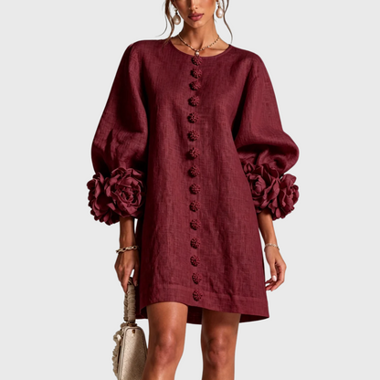 Front view of the dress in deep burgundy on a model, showing the flower buttons and rosette cuffs. 7