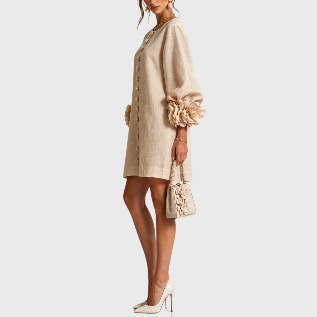Side view of the beige dress on a model with cream heels and a small floral bag, showing the puff sleeve. 10