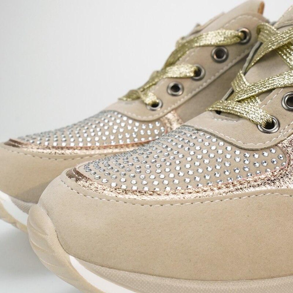 Close-up of the toe area of the beige trainers, showing the rhinestone-studded panel, metallic gold laces and rose-gold edging. 10