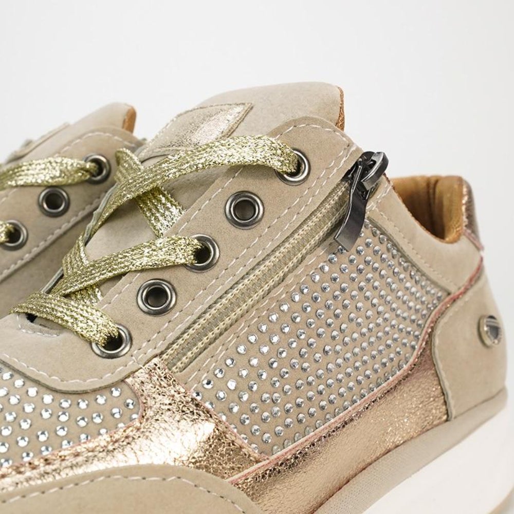 Close-up of the beige trainers' laces and side zip, showing the metallic gold laces, metal eyelets and rows of rhinestones. 8
