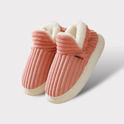 Pair of coral pink ribbed fleece-lined slippers with thick cream soles, shown on a plain light background. 17