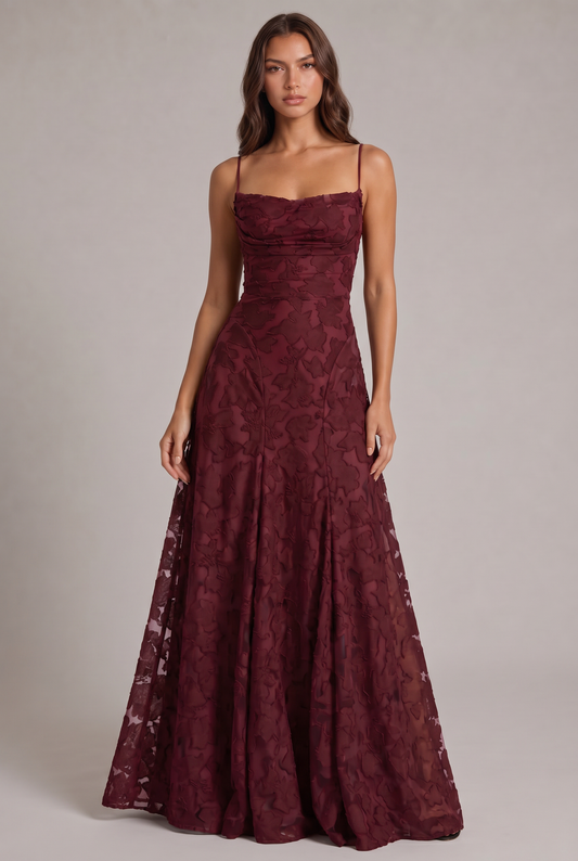 Model wearing the burgundy floral-textured maxi dress with thin straps and a draped neckline, full-length front view. 1