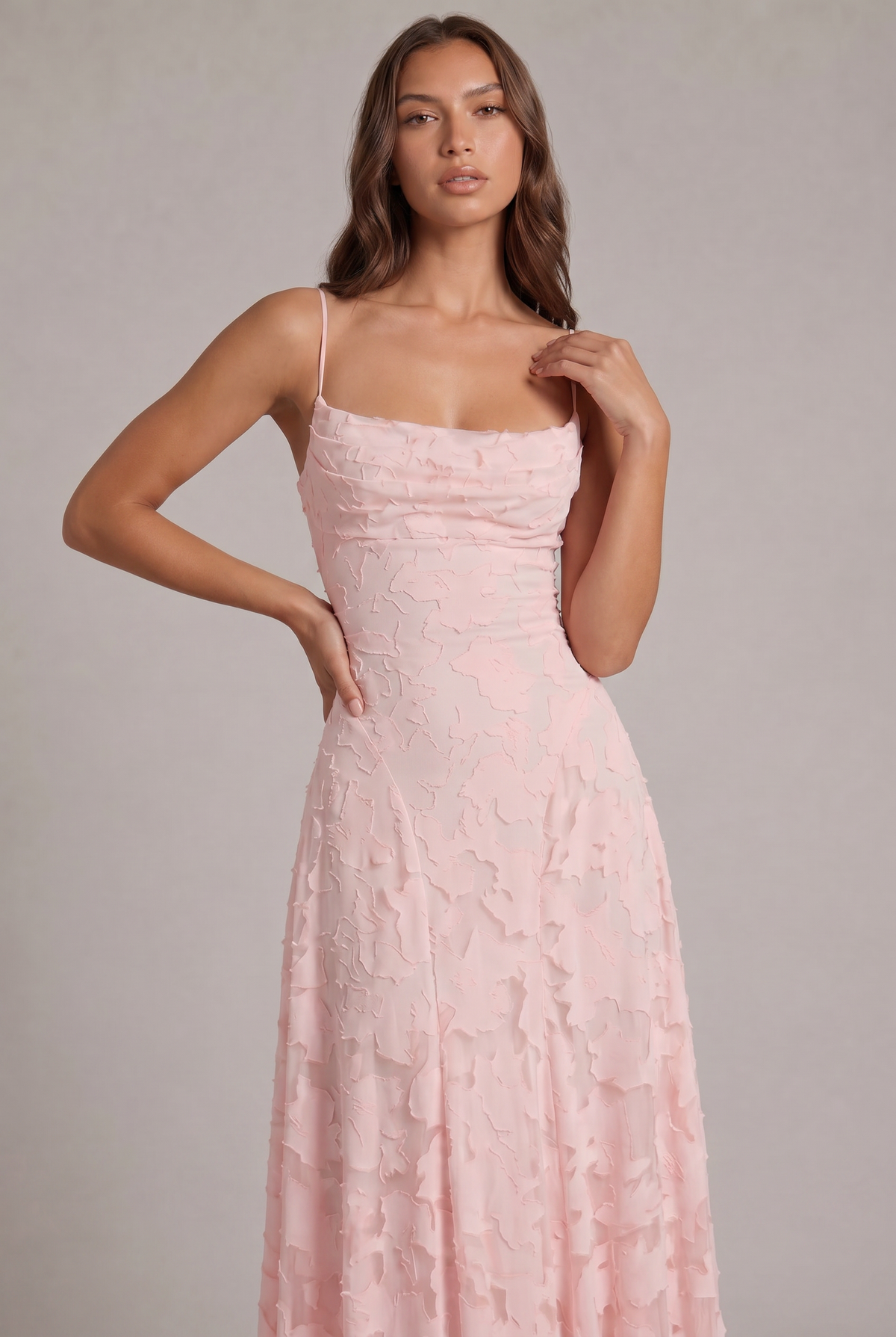 Close-up of the pale pink dress bodice on a model, showing the draped neckline and raised floral texture. 6