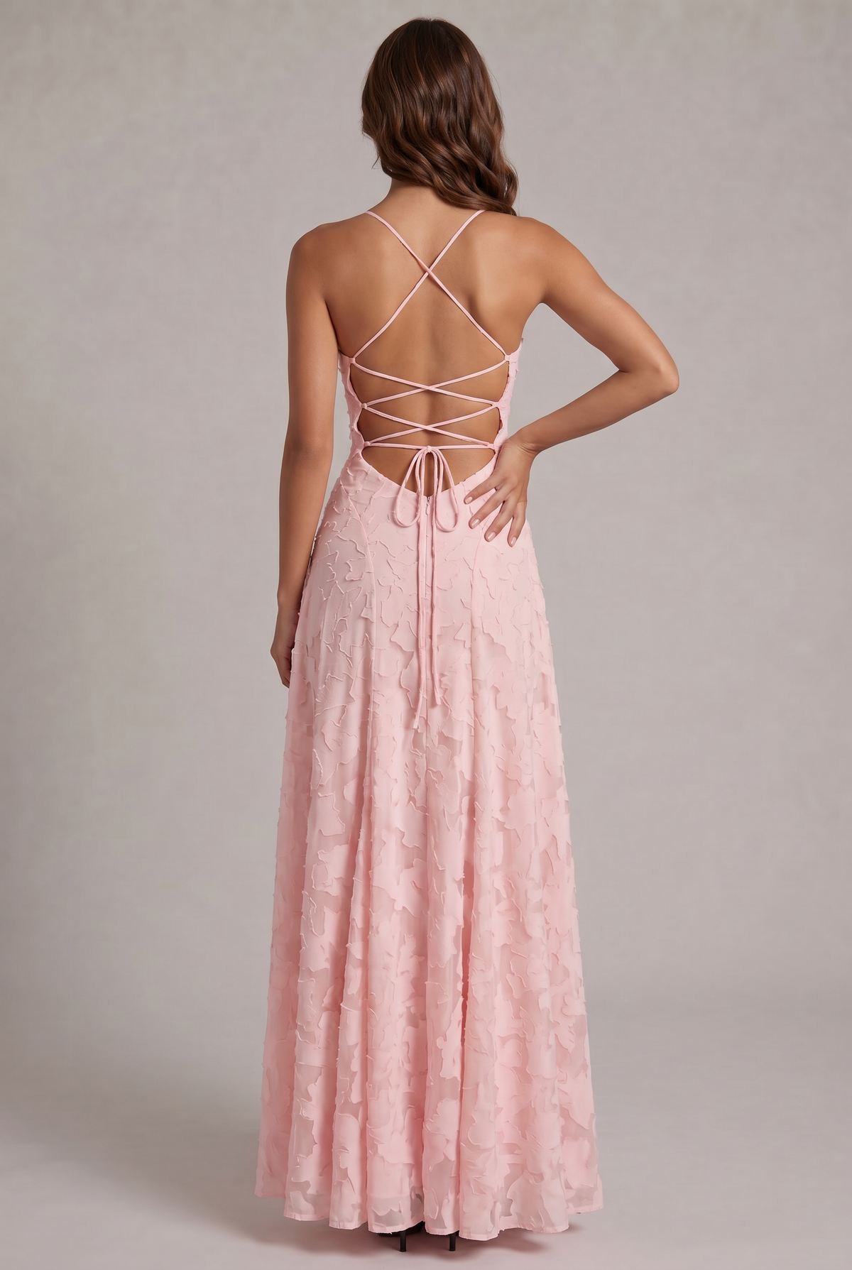 Back view of the pale pink maxi dress, showing the criss-cross lace-up open back with a bow tie and zip. 7