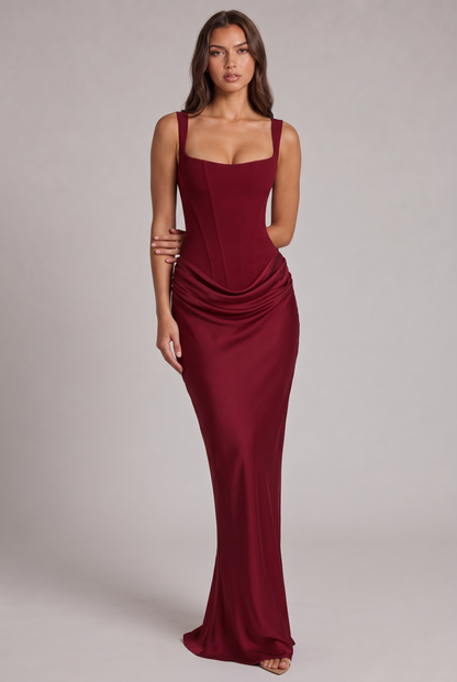 Model wearing the burgundy maxi dress, front view, showing the corset bodice, square neckline and draped satin-look skirt. 17