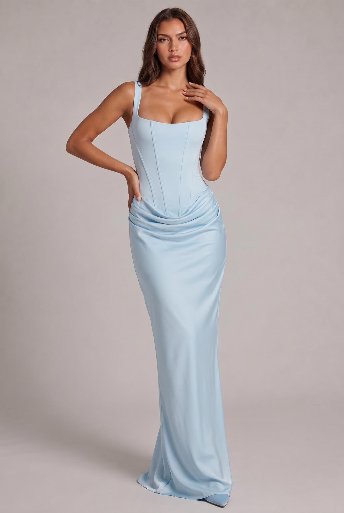 Model wearing the pale blue satin-look maxi dress, front view, with a hand on her collarbone, showing the corset bodice and draping. 13