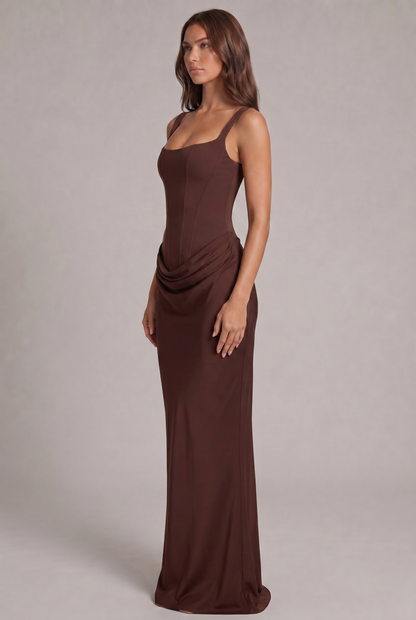 Side view of the chocolate brown maxi dress, showing the fitted corset bodice and the draped fabric at the hip. 3