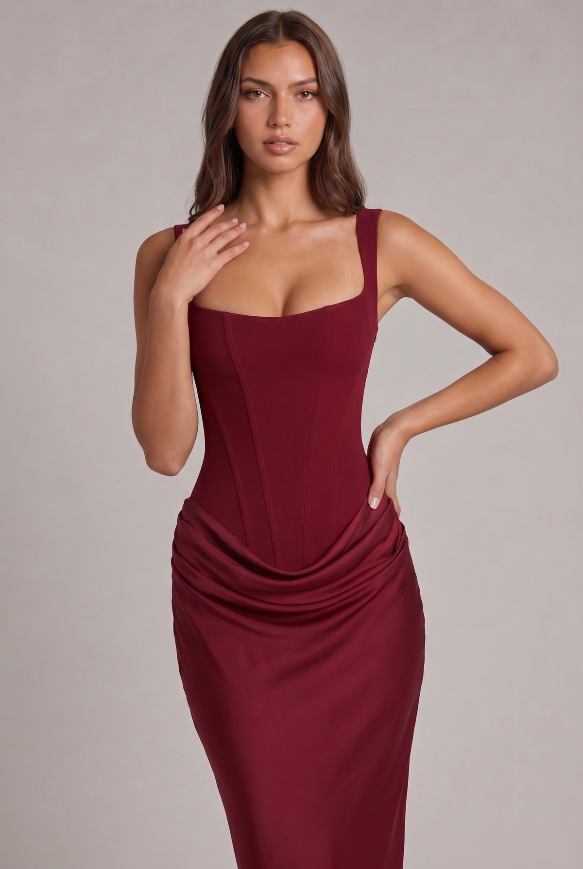 Close-up of the burgundy dress, with one hand on her shoulder and one on her hip, showing the corset seams and draping. 18