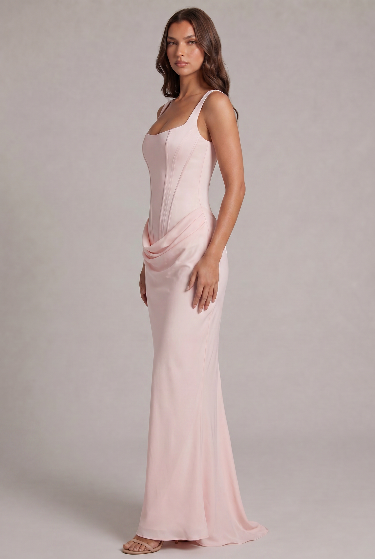 Side view of the pale pink maxi dress, showing the fitted corset bodice, draped hip detail and flowing skirt with a small train. 27