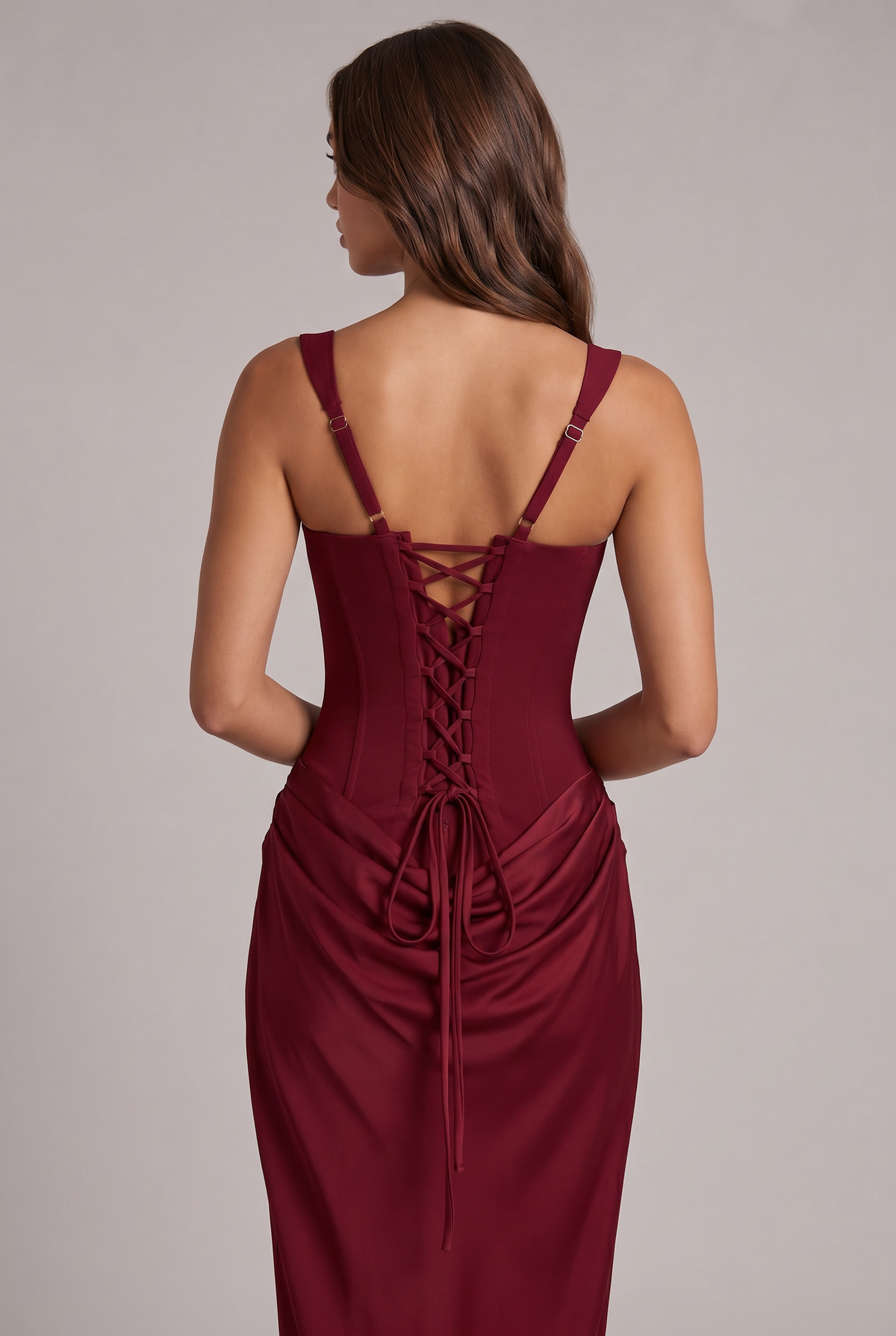 Close-up back view of the burgundy dress, showing the lace-up corset back, adjustable straps and long ties over the draped skirt. 20