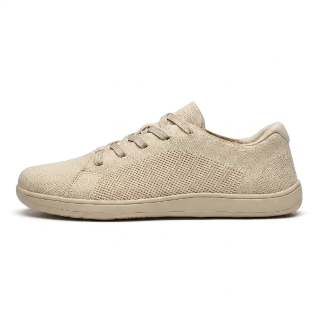 Side view of a beige knit lace-up trainer with a perforated mesh panel and a flat, flexible sole. 1