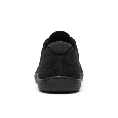 Rear view of a black knit trainer showing the padded heel collar, mesh heel panel and flat sole. 18