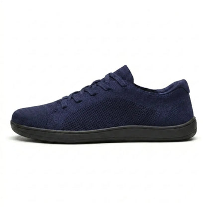 Side view of a navy blue knit lace-up trainer with a mesh panel and a flat black sole. 19