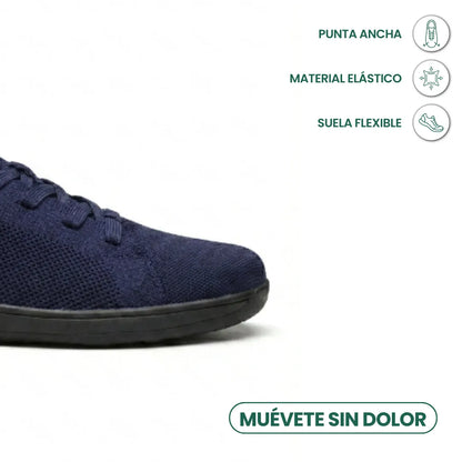 Close-up of the rounded toe of a navy knit trainer with black sole, with feature icons above. 23