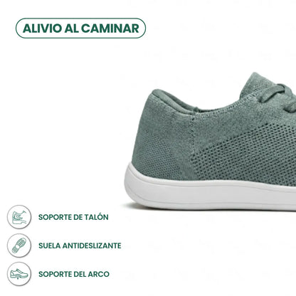Close-up of the heel and side of a sage green knit trainer with white sole, with small feature icons beneath. 31