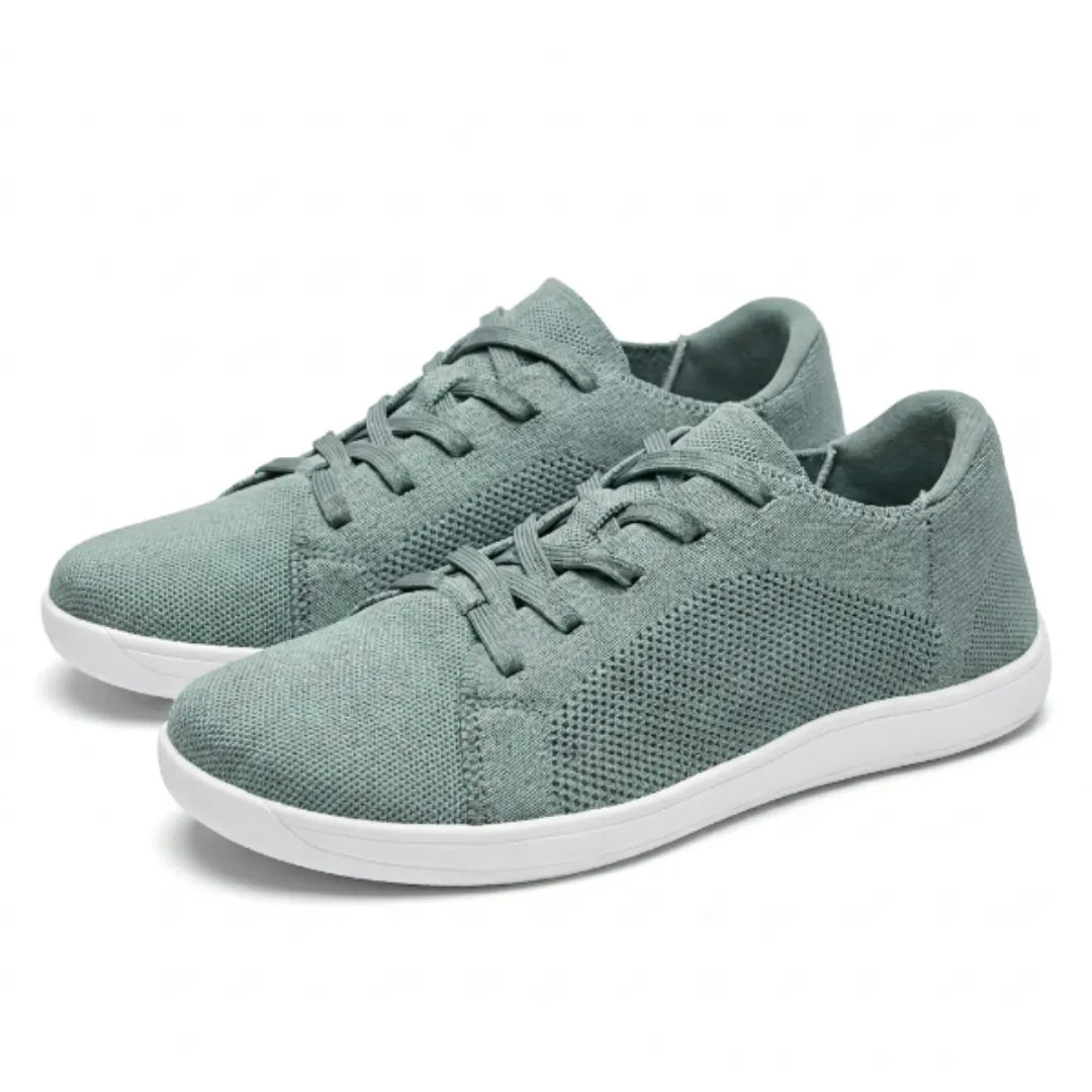 Pair of sage green mesh lace-up trainers with white soles, angled three-quarter view on a plain background. 34