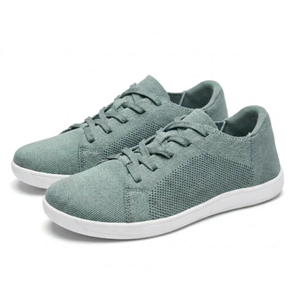 Pair of sage green mesh lace-up trainers with white soles, angled three-quarter view on a plain background. 34