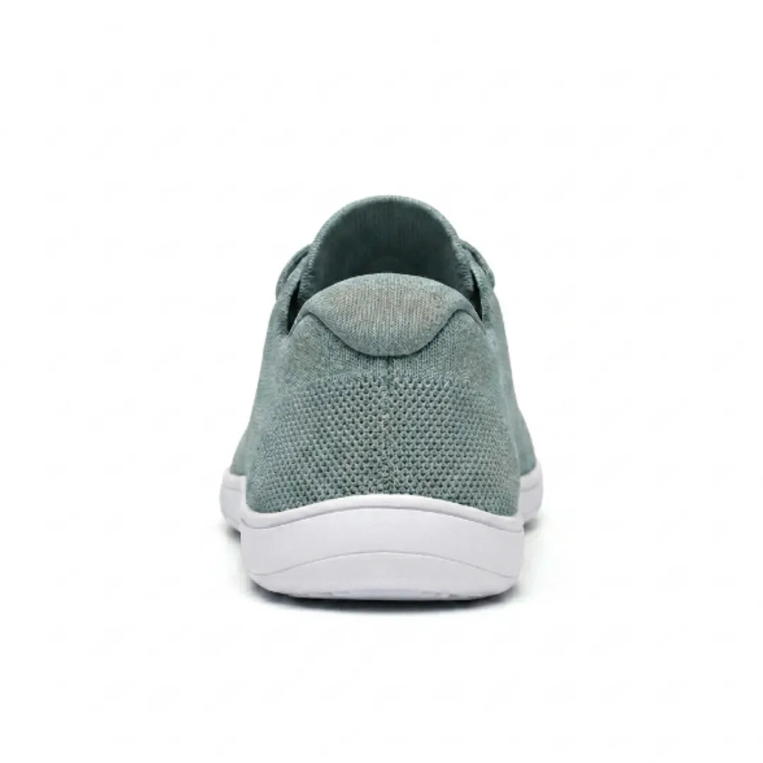 Sage green knit trainer seen from behind, showing the heel tab, textured mesh and flat white sole. 36