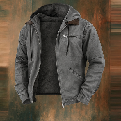 Grey version of the hooded jacket, open at the front with dark fleece lining and brown collar trim, on a rust-toned backdrop. 3