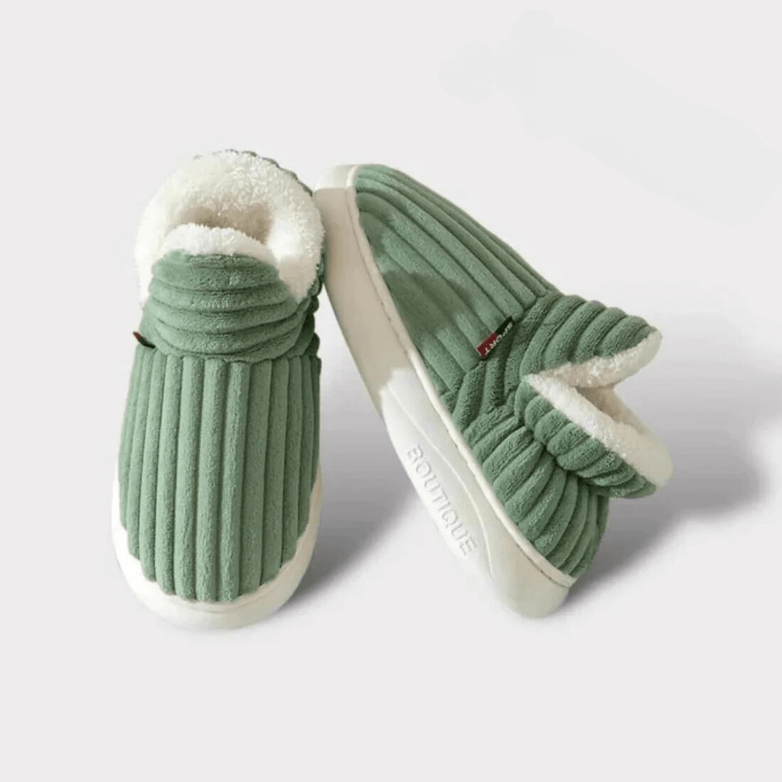 Pair of green ribbed fleece-lined slippers on a plain background, one upright and one tilted to show the sole. 16