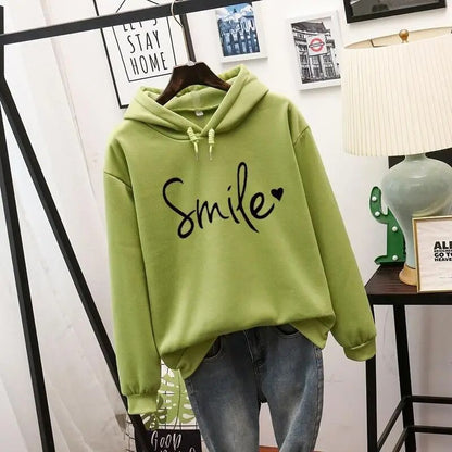 Light green hooded sweatshirt with black script slogan and small heart, drawstring hood and ribbed cuffs, hung over blue jeans. 5