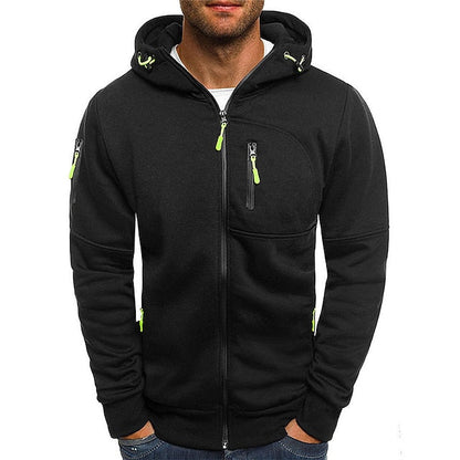 Front view of the black zip-up hoodie on a model, with lime green zip pulls and hands in the pockets. 5