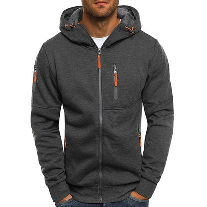 Man wearing the dark grey zip-up hoodie from the front, with orange zip pulls and a grey hood lining. 6