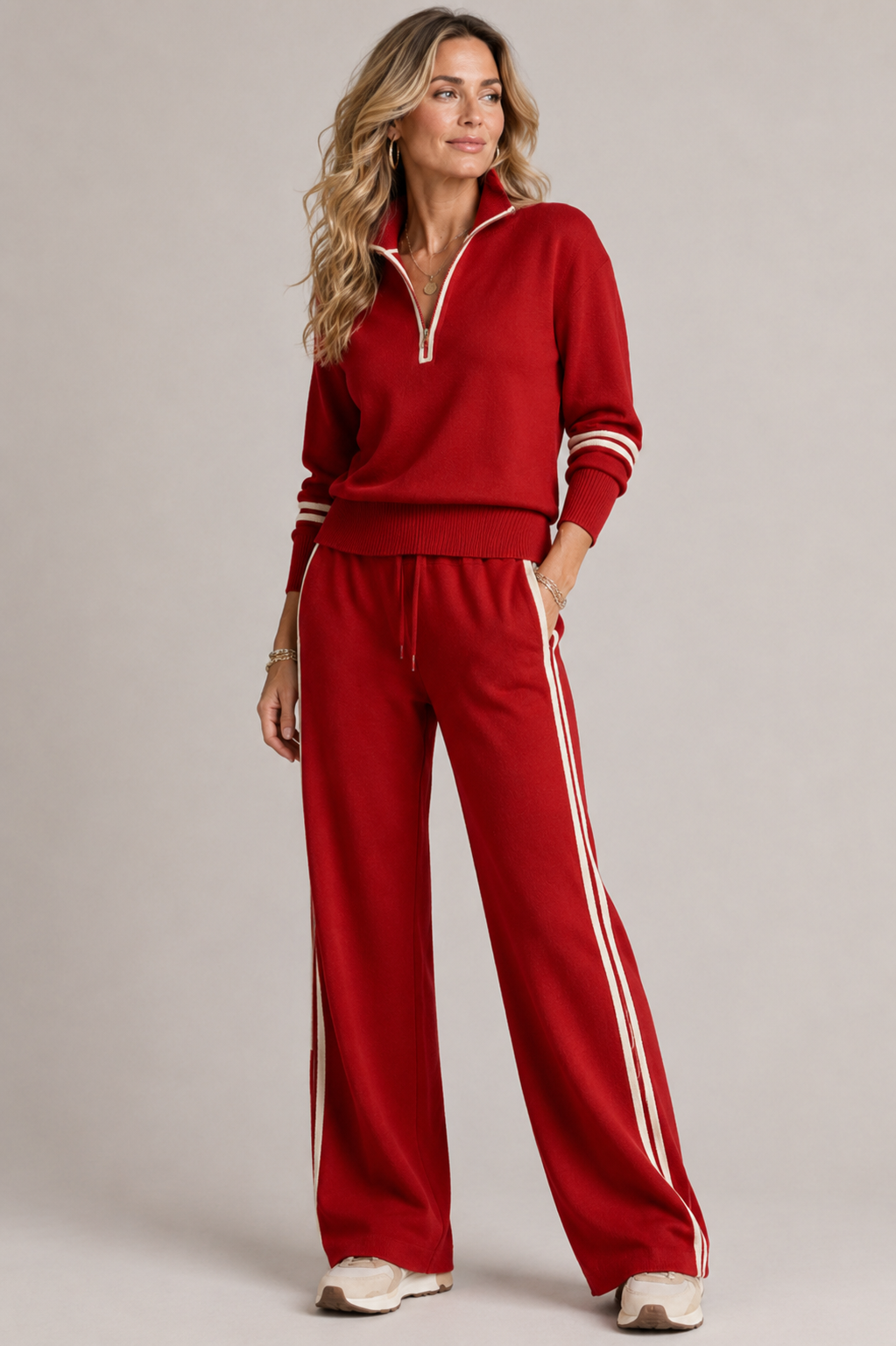 Model posing in the red set with cream piping on the zip and sleeves, plus cream side stripes down the trousers. 4