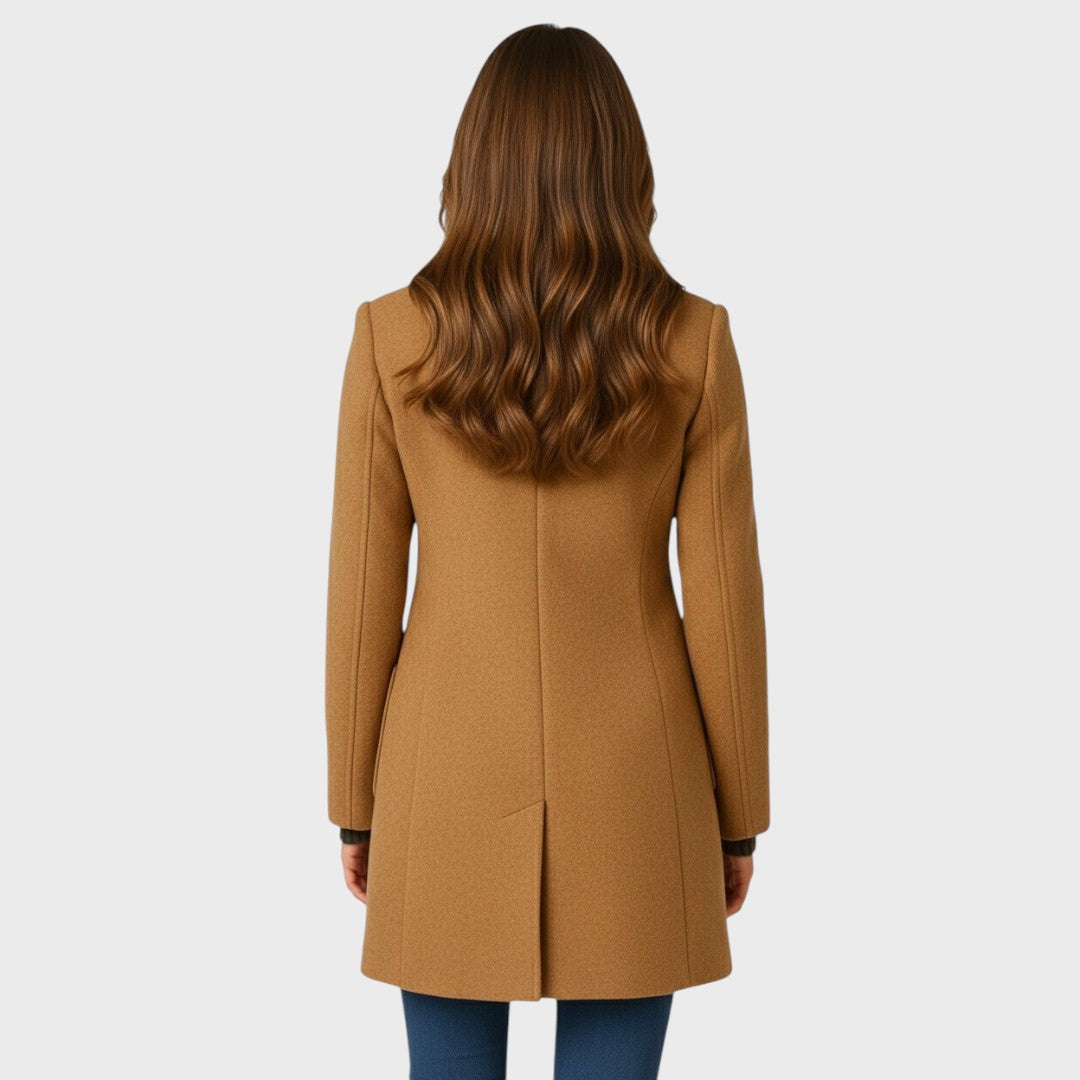 Back view of the camel coat on a model, showing the plain panelled back and centre vent at the hem. 8