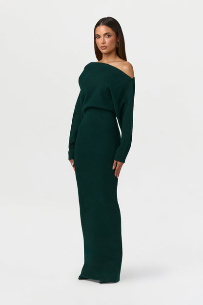 Angled side view of the dark green knit maxi dress, showing the neckline and slim column fit. 13