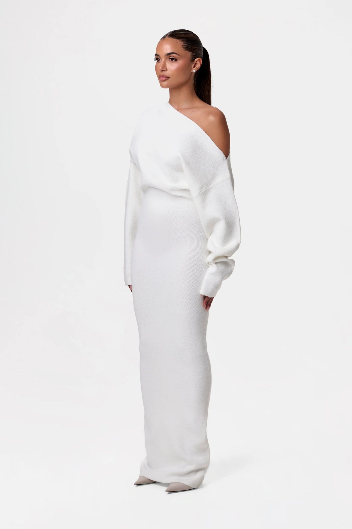 Side view of the cream-white knit maxi dress, showing the bare shoulder, full sleeve and slim silhouette. 7