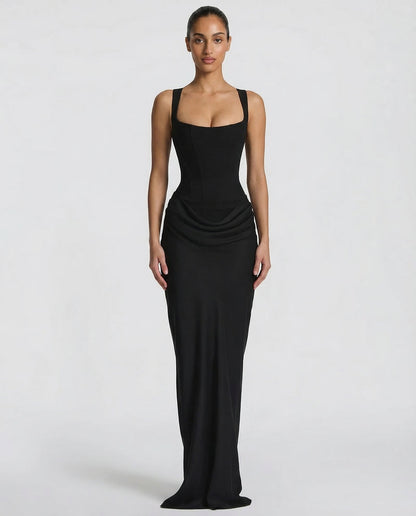 Black maxi dress with a structured square-neck corset bodice and draped hip detail, shown full-length from the front on a model. 1