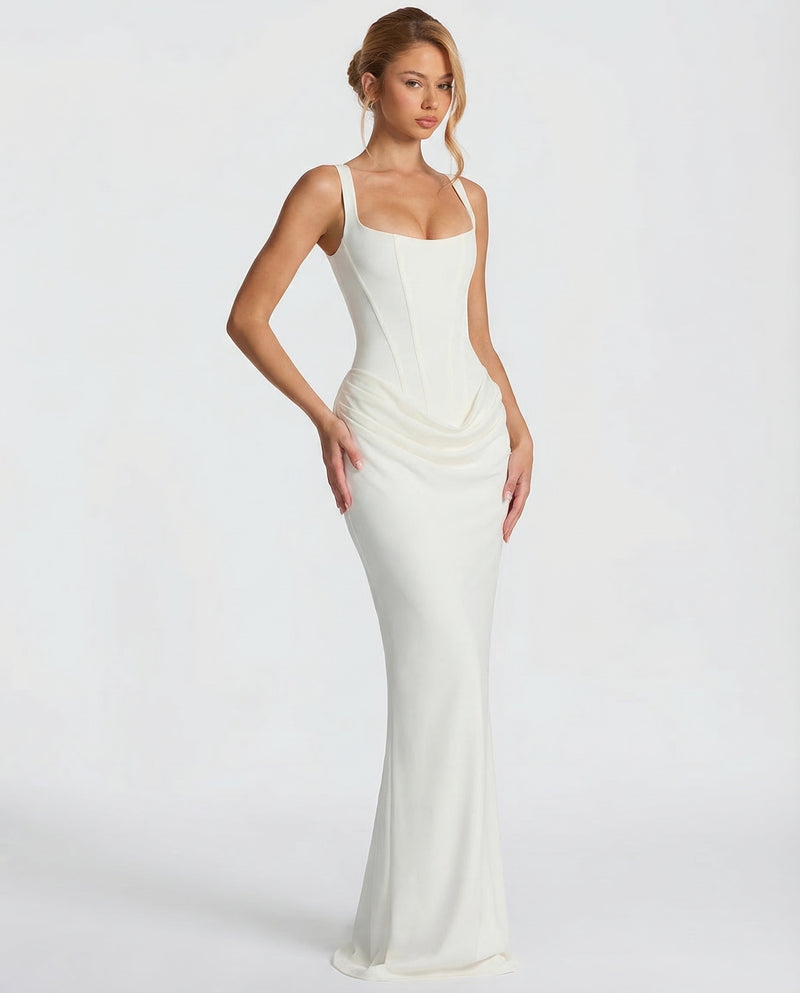 Ivory corset maxi dress worn at an angle with one hand on hip, showing the draped hip and flared hem. 8