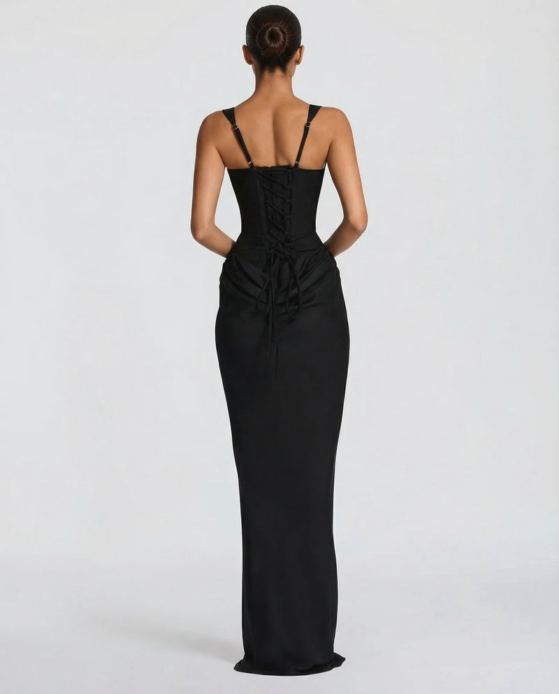 Back view of the black dress showing adjustable straps, the lace-up corset back with trailing ties and the draped skirt. 2