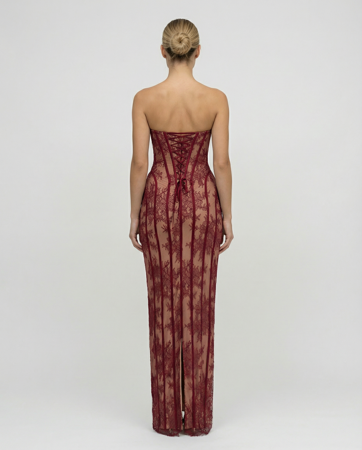 Back view of the burgundy lace dress, showing the corset-style lace-up back with a bow and the centre slit at the hem. 2