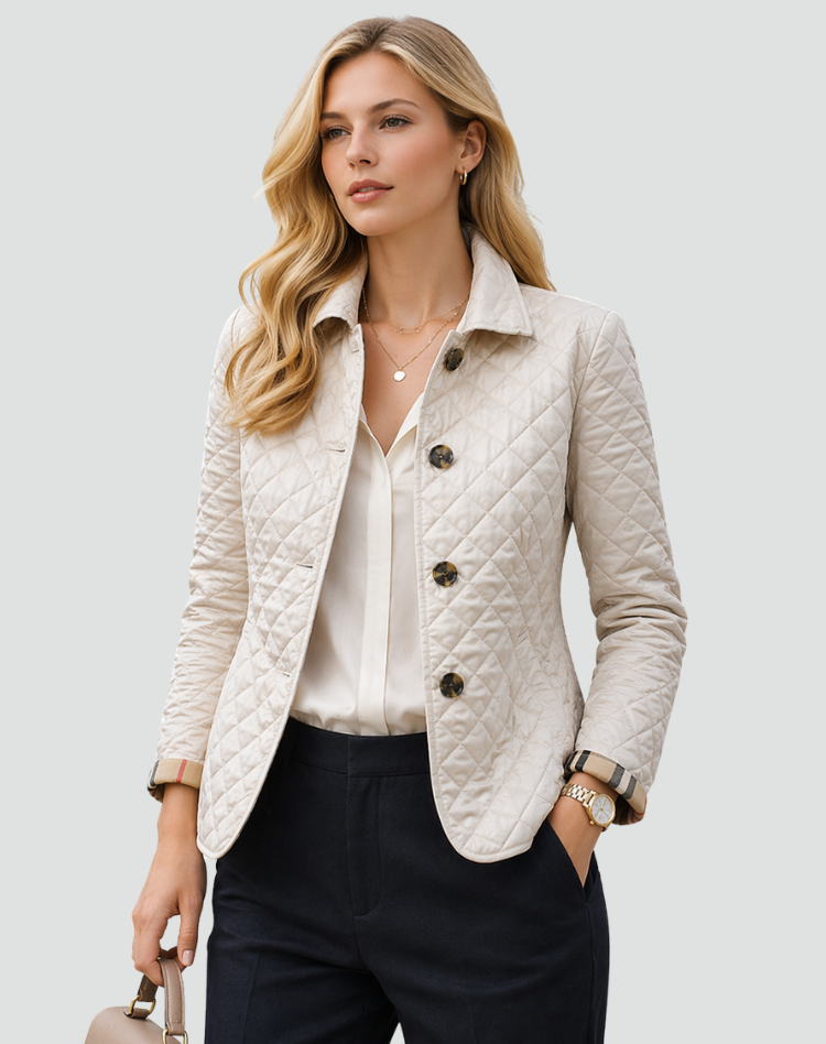 Model in the cream quilted jacket with tortoiseshell-style buttons, worn over a cream blouse and navy trousers, holding a handbag. 2