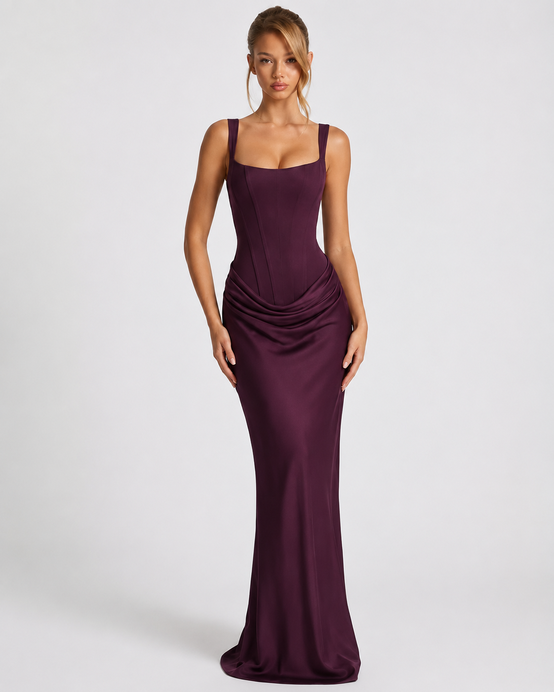 Front view of the dark plum satin dress on a model, with a seamed corset bodice, wide straps and a draped hip. 13