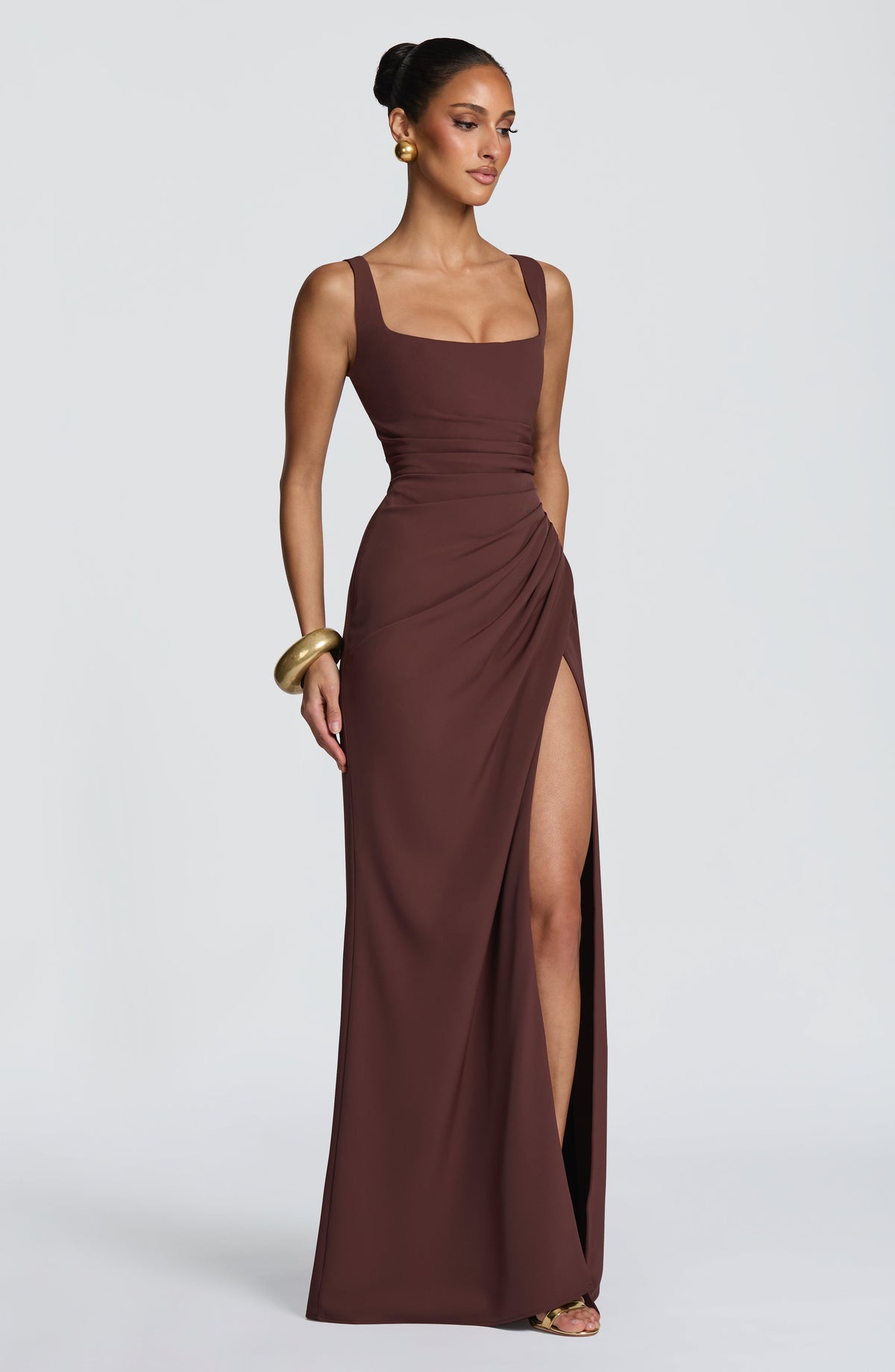 Three-quarter view of the brown dress on a model, showing the gathered hip and high thigh slit. 3