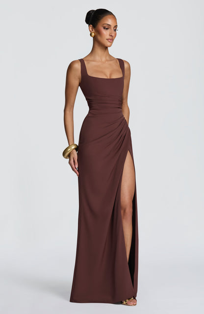 Three-quarter view of the brown dress on a model, showing the gathered hip and high thigh slit. 3