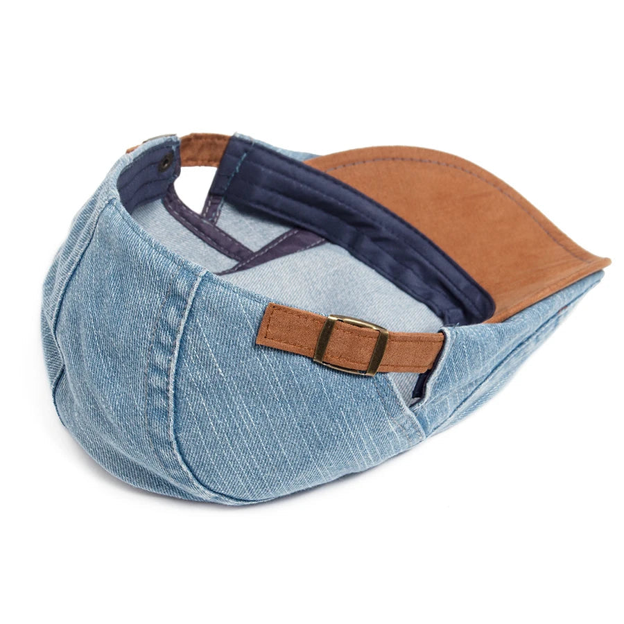 Light blue denim flat cap turned over to show the navy inner lining, tan underside of the peak and adjustable rear strap. 10