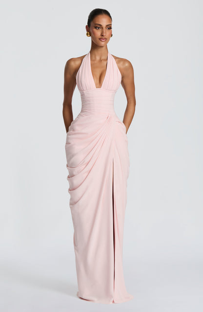 Full-length front view of the pale pink dress on a model, standing with hands behind her and the slit just visible. 6